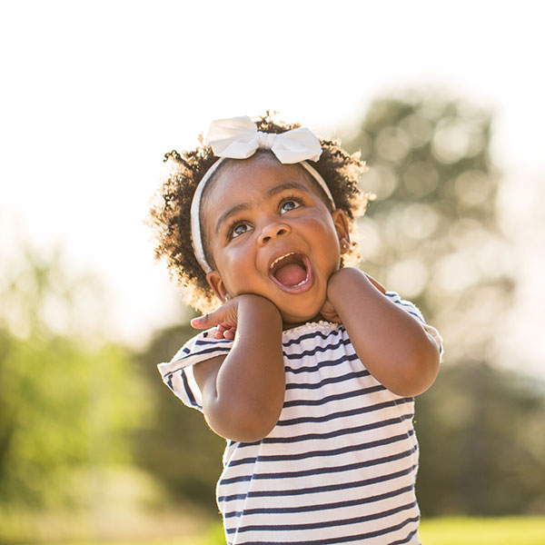 Young Girl Smiling Outdoors looking at the sky